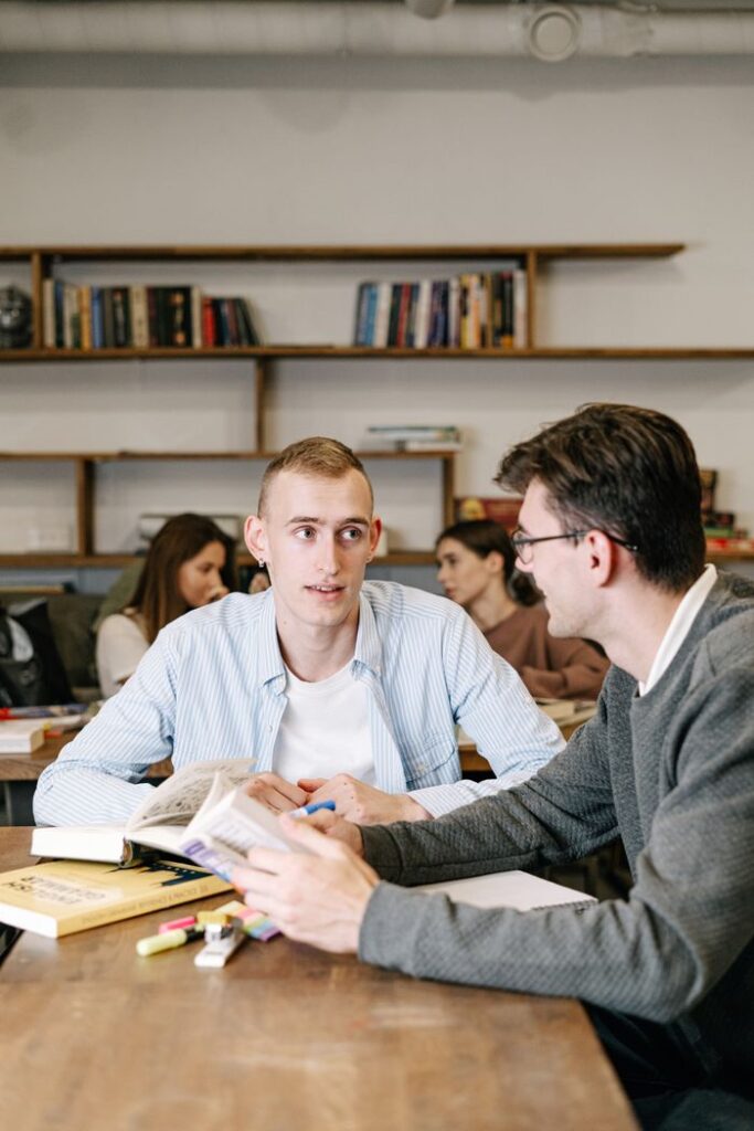 Group of young adults discussing in a study group indoors, focusing on teamwork and learning.